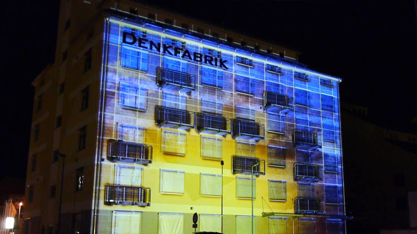 The Denkfabrik building in Magdeburg covered in a projection mapping at night