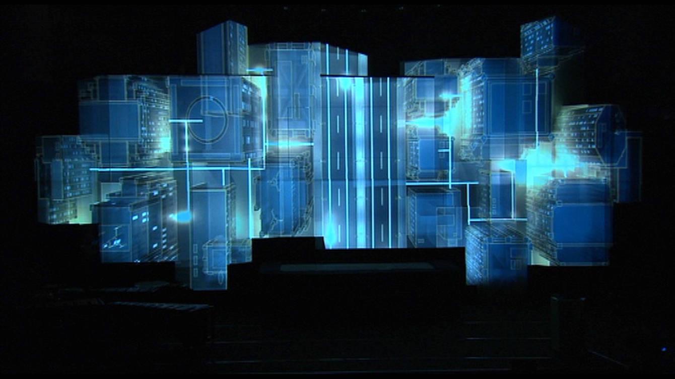 A stage of stacked projection-mapped cubes glowing blue during the Hannover Messe opening ceremony