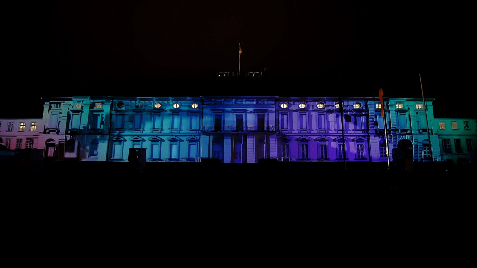 The façade of Schloss Bellevue in Berlin with a 3D projection mapping of colourful patterns during the Bürgerfest